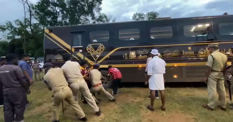 നവകേരള ബസ് ചെളിയില്‍ പുതഞ്ഞു; കയർ കെട്ടി വലിച്ച് പോലീസുകാർ